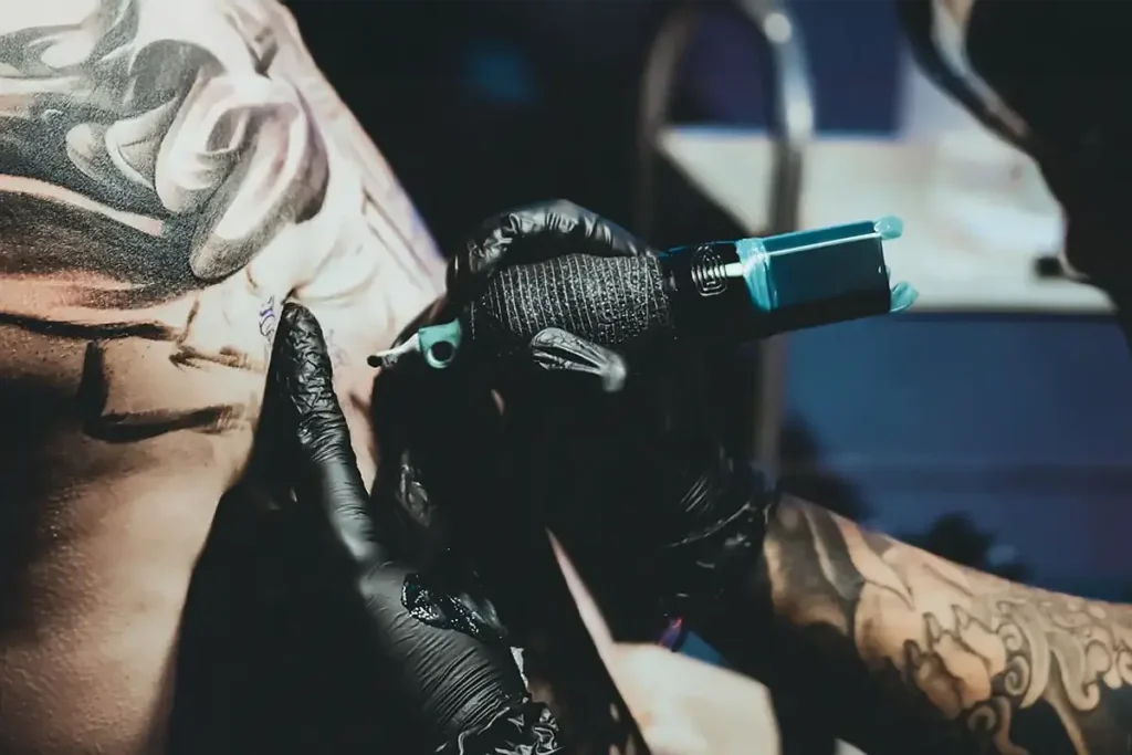 Tatoueur balinais en plein travail dans son studio de tatouage &agrave; Bali